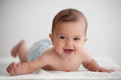 Smiling Baby Girl Lying On Stomach