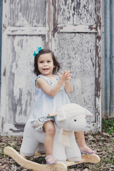 Cute Baby Girl On Toy Horse