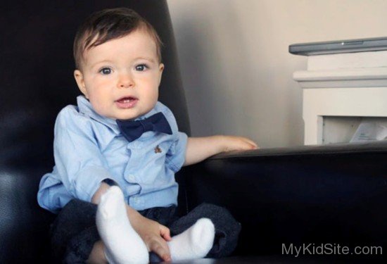 Dashing Baby Boy Sit On Black Sofa-Sn12321