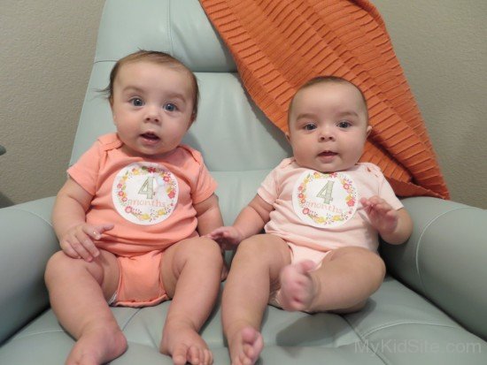 Twins Sitting On Sofa