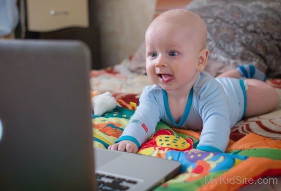 Charming Baby Boy Looking At Laptop