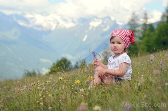Cute Baby Girl Sitting On Grass
