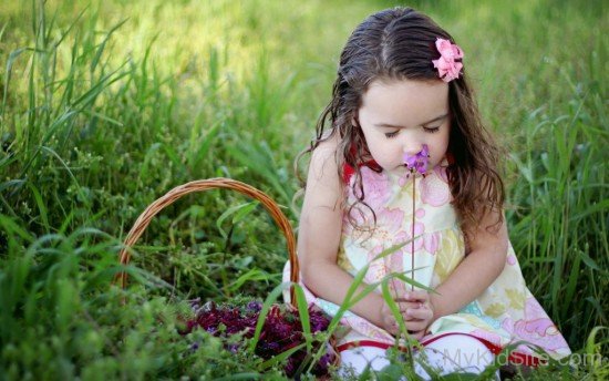 Baby Girl Smelling Flowers