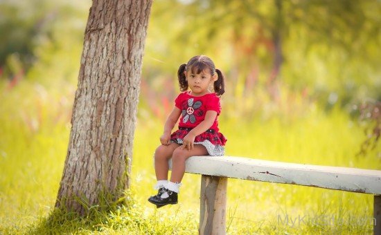 Sad Little Girl Sitting On Bench